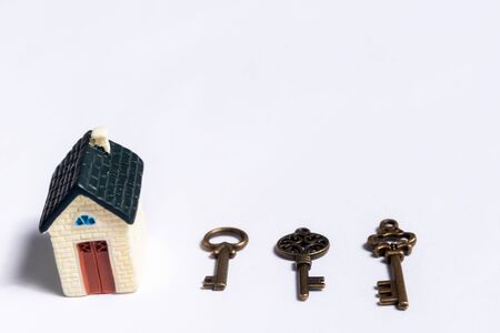 Different keys and a little house on a white background, concept of real estateの写真素材