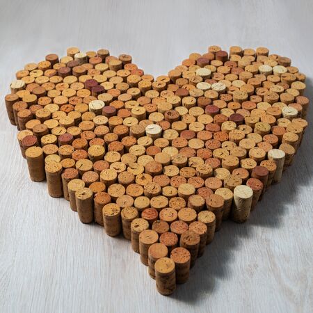 Big heart made of cork wine corks on wooden background, wine design concentの写真素材