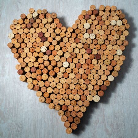 Big heart made of cork wine corks on wooden background, wine design concentの写真素材