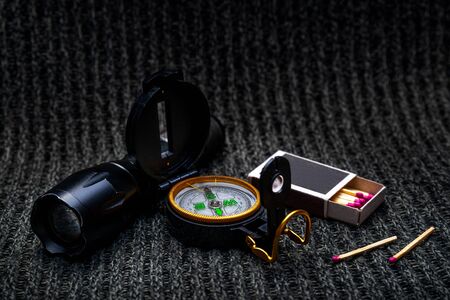 Flashlight, compass, matches on a gray fabric background, travel survival kitの写真素材