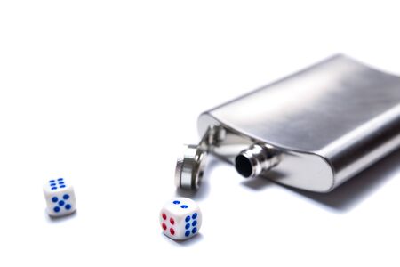 Dice and open metal flask for alcohol on a white background, concept of pastime, entertainment, holidays, quarantineの写真素材