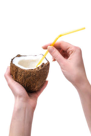 Drink in half coconut in female hands with a straw on  whiteの写真素材