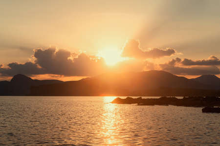 Golden sunset mountain sea coastの写真素材