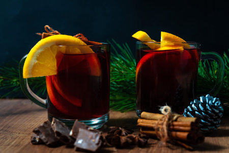 Mulled wine with aromatic spices and orange pieces on a wooden backgroundの写真素材