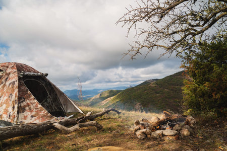 Tent in the mountains near a campfire on a hike in a tourist camp, activity, rest, relaxation, silenceの写真素材