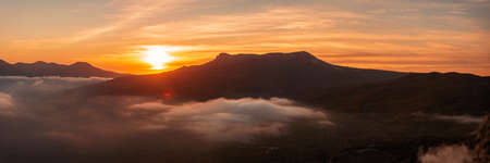 Golden sunset over the mountain range, panoramic viewの写真素材