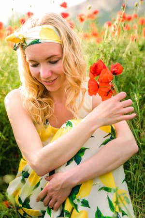 Blonde girl in a black bodysuit with a white hat walks in a rapeseed field, having fun, view from the backの写真素材