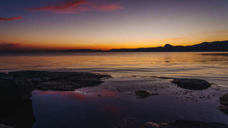 Lilac sunset on the sea coast, quiet sea, resortの写真素材
