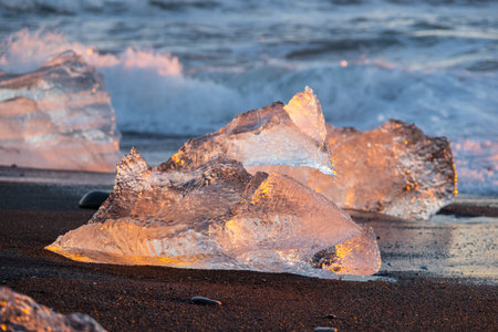 Diamond Beach in Iceland. Icebergs Shining on Black Volcanic Sand at Sunset. Clear Ice Crashed by Ocean Waves. Famous Tourist Location in North Europe Country. Travel Destination. High Resolutionの写真素材