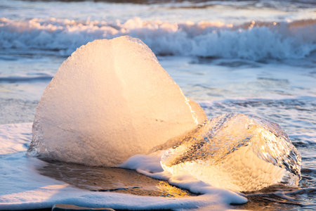 Diamond Beach in Iceland. Icebergs Shining on Black Volcanic Sand. Clear Ice Crashed by Ocean Waves.