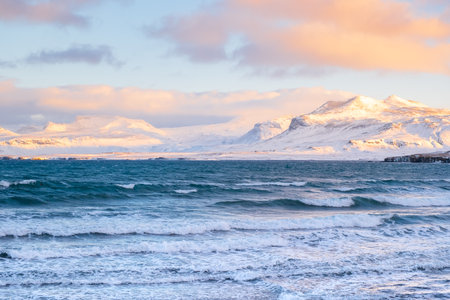 Sunrise Fluffy Clouds and Stormy Sea with Snowy Mountain in Iceland. Landscape in North Europe Country. Atlantic Ocean Coast and Icelandic Fjords.の写真素材