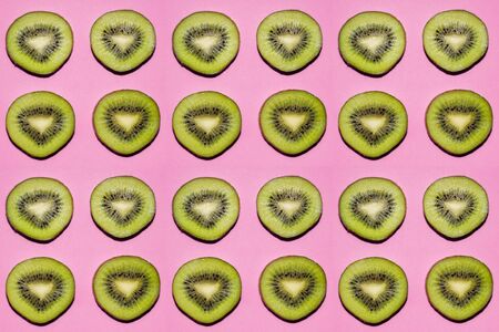 Fruit pattern. Slices of kiwi fruit on pink backgroundの写真素材