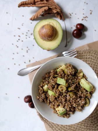 Buckwheat porridge with avocado, green olives, and chili pepper. Vegetarian food. Homemade healthy foodの写真素材