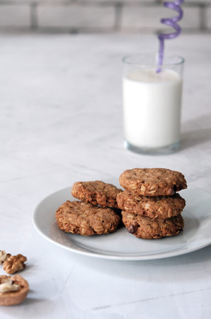 Cozy homemade oatmeal cookies and a glass of milk. Breakfast concept. Vertical composition