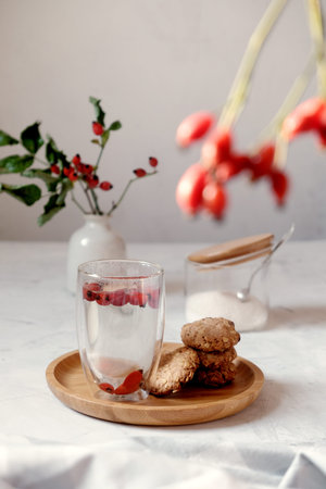 Rosehip tea with homemade homemade cookies. Folk medicine concept. Herbs cup. Vertical composition