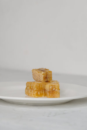 Pieces of honeycomb with honey on the white plate closeup