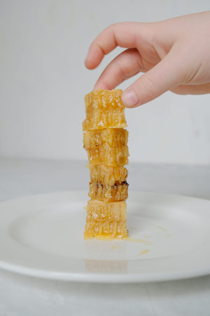 Pieces of honeycomb with honey on the white plate closeup with nand