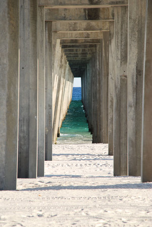 Looking under the broadwalk through to the Atlantic ocean with white sand and the timberの写真素材