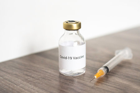 Vaccine bottle and syringe on wooden table. Vaccination conceptの写真素材