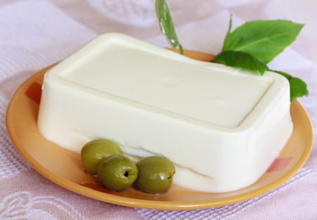 Olives, cream cheese and basil on the orange plateの写真素材