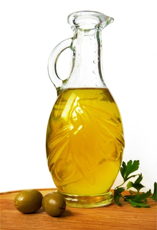 A bottle of olive oil and a couple of olives nearの写真素材