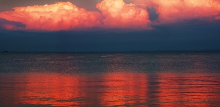Sunset clouds reflected in the sea waterの写真素材