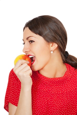 Pretty young woman eating apple, isolated on whiteの写真素材