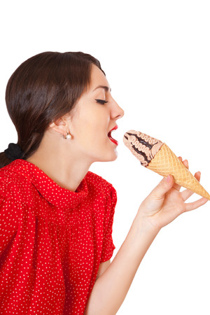 Pretty woman in red dress eating ice cream, isolated on white backgroundの写真素材
