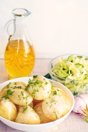 Fresh boiled potatoes with oil and saladの写真素材