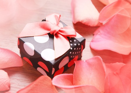Gift box with bow and rose petalsの写真素材