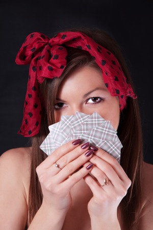 Pretty woman with playing cards in hands on a black backgroundの写真素材