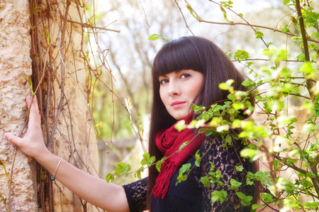 Portrait of girl in spring park near the wallの写真素材