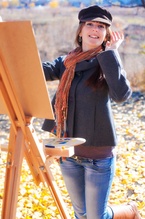 Young woman having fun laughing near easelの写真素材
