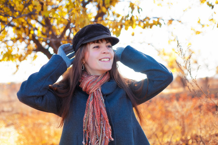 Smiling girl in autumn near a treeの写真素材