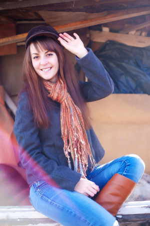 Cheerful girl in a cap sitting on a benchの写真素材