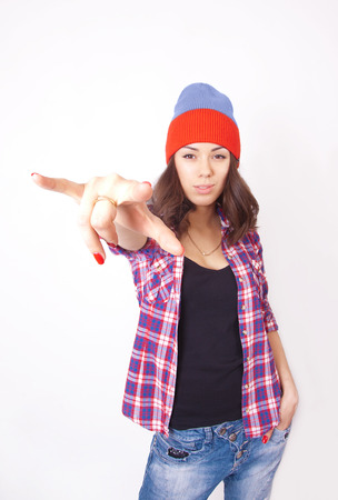 Cute hipster teenage girl with beanie hat posing looking at cameraの写真素材