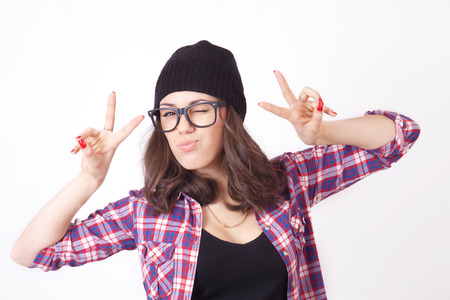 Cute hipster teenage girl with beanie hat posing looking at cameraの写真素材
