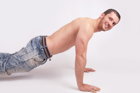 A young man pushed off the floor, studio shotの写真素材