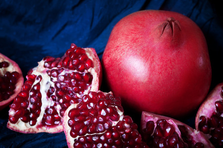 Juicy ripe pomegranates on dark blue backgroundの写真素材
