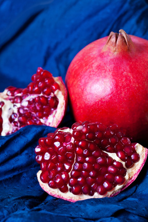 Juicy ripe pomegranates on dark blue backgroundの写真素材
