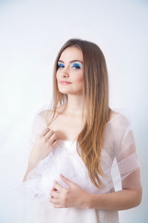 Beauty young woman studio portrait on blue backgroundの写真素材