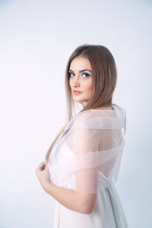 Winter beauty young woman studio portrait on blue backgroundの写真素材