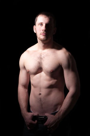 Portrait of shirtless handsome man, black backgroundの写真素材