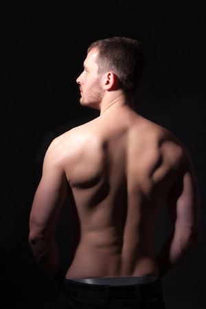 Rear view of a well-built bare-chested young manの写真素材
