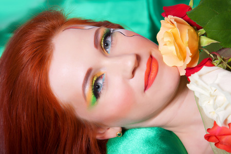 Portrait of beautiful red-haired girl with flowers and bright makeupの写真素材