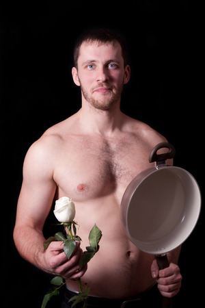 Man with a frying pan and a flower on a black backgroundの写真素材