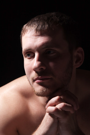 Image of shirtless man keeping his hands by face while thinkingの写真素材