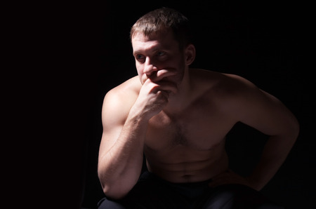 Image of shirtless man keeping his hands by face while thinkingの写真素材
