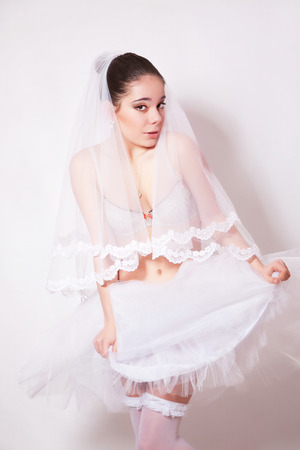Bride in a skirt, underwear and stockings on gray backgroundの写真素材
