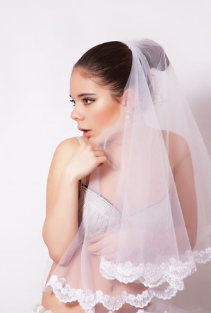 Portrait of a beautiful bride in veil, gray backgroundの写真素材